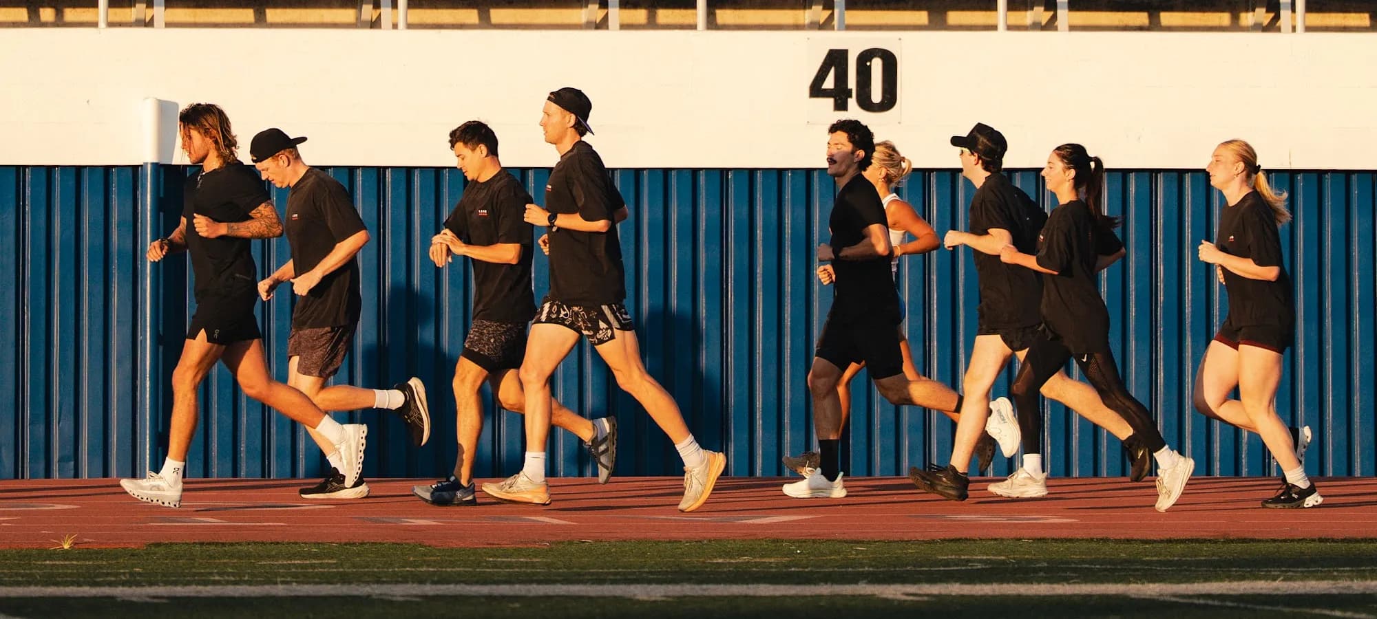 The Kyde track club running as a pack past the grandstand at golden hour